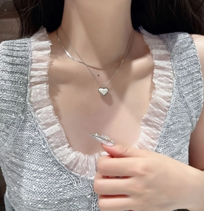 Detailed view of layered titanium steel snake bone necklace with polished heart pendant