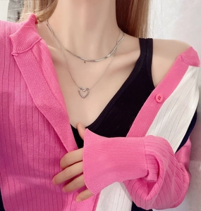 Detail of silver double-layered snake chain necklace with hollow heart pendant on neck