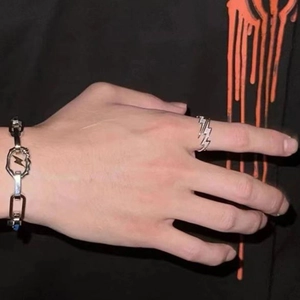 Close-up of silver lightning bolt ring and chunky link bracelet on model hand