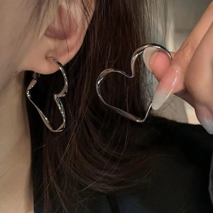 Irregular liquid metal heart hoop earrings in bright silver finish for a bold minimalist style