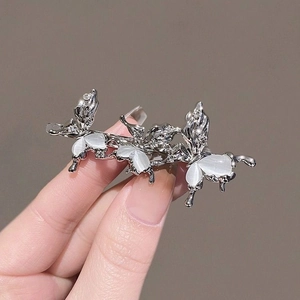 Vue détaillée d'une barrette argentée avec trois papillons en œil de chat et strass