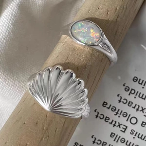 Vintage-Ring-Set mit Muschel und Opal auf Holzständer für maritim inspirierten Schmuck