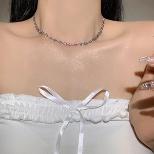 Vue rapprochée d'un collier ras du cou à fleurs colorées argentées sur un modèle