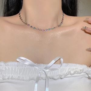 Détail d'un collier de fleurs argenté orné de pierres colorées sur un mannequin