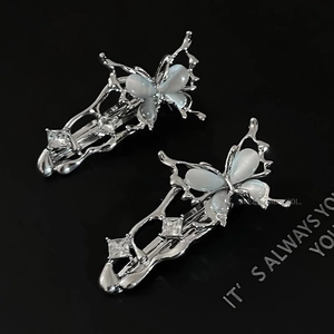 Barrettes papillon argentées avec pierres œil de chat bleues et détails en zircone