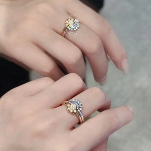 Dettaglio di anelli sole e luna con cristalli blu e metallo oro-argento sul dito