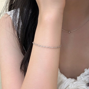 Vista macro de una pulsera minimalista de cadena de cuerda plateada para mujer