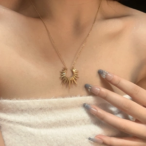 Golden sunburst pendant necklace for women and men, featuring a polished vintage star design