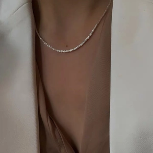 Sparkling silver minimalist layered necklace for women styled with a white blazer suit