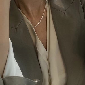 Close-up of a sparkling silver tennis necklace worn on a woman's neck for a minimalist look