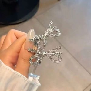Primo piano dettagliato di fermagli per capelli a fiocco argento con strass lucidi