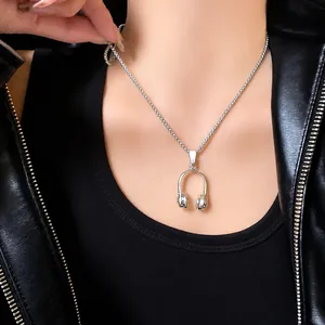 Detail van zilveren hoofdtelefoon hanger ketting met gedraaide ketting op een leren jas