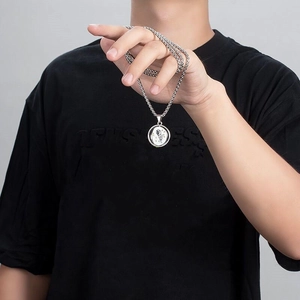 Detailed close-up of a rotating astronaut pendant on a silver box chain necklace