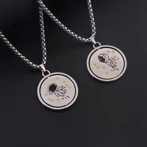 Macro detail of rotating astronaut pendants on high-quality stainless steel box chains
