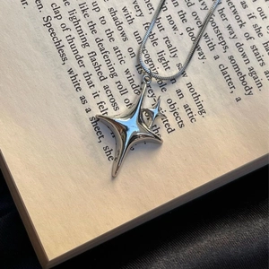 Collier pendentif étoile argenté Y2K sur un livre, bijoux en acier inoxydable