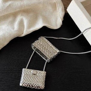 Mini silver woven bag pendant necklace with a fine chain for stylish layered outfits