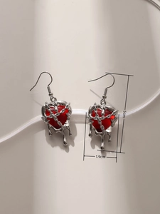 Detailed view of punk style red resin heart earrings with molten silver metal frame