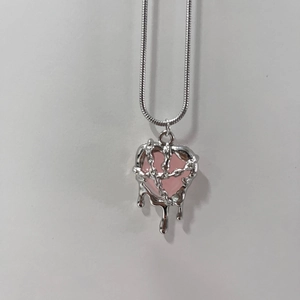 Detailed close-up of punk style heart pendant with pink resin and silver liquid metal effect