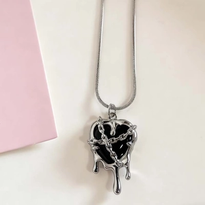 Detailed close-up of a gothic lava heart pendant with black resin and fluid silver metal