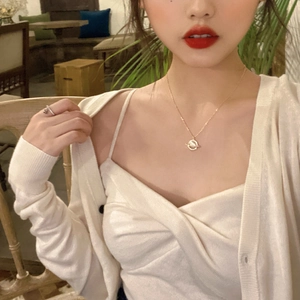 Saturn planet pendant necklace with zircon on a model wearing cream knitwear