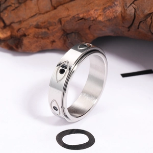 Gros plan d'une bague rotative en acier avec motif œil grec et pierres noires