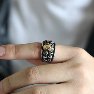 Macro detail of gothic skull ring featuring central gold skull on silver metal band
