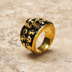 Detail of vintage gold skull embossed stainless steel ring with black aged finish