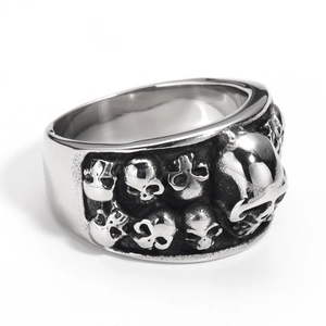 Macro shot of punk style stainless steel ring with detailed skulls and polished finish