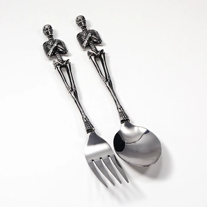 Detail of gothic stainless steel cutlery set featuring creative skull skeleton handles