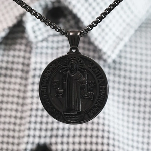 Primer plano del colgante de medalla de San Benito negro en cadena de eslabones cuadrados
