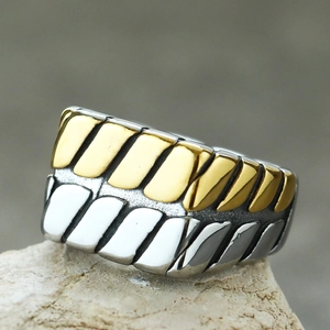 Makroaufnahme des breiten Punk-Rings mit goldenen und silbernen geometrischen Streifen