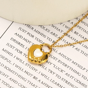 Gros plan du pendentif cadenas cœur doré avec insert blanc et gravure logo COO