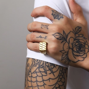 Details des breiten Goldrings mit diagonalen Rillen an der Hand eines Mannes