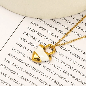 Détail d'un pendentif cadenas cœur en or 18k avec émail blanc sur une chaîne fine en O