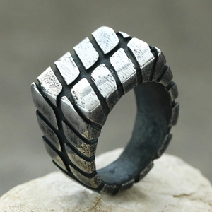 Makroaufnahme der Reifenprofil-Textur des Vintage-Stahlrings auf weißem Stein