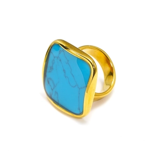 Dettaglio macro di anello placcato oro con pietra di turchese quadrata e venature