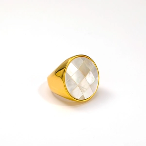 Dettaglio di un anello dorato con intarsio geometrico in madreperla a quadretti
