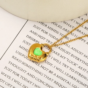Gros plan du pendentif cadenas cœur en or 18k avec émail vert marbré et gravure GOG