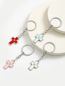 Detail view of four colorful alloy double cross keychains on white display stand