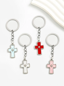 Detail shot of assorted colorful alloy double cross keychains in blue, red, pink, and white