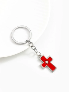 Macro detail of silver-tone alloy keychain with red enamel double cross pendant charm