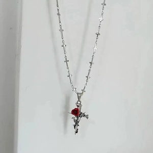 Makro-Detail der silbernen Kreuzkette mit roter Rose und Links im Gothic-Stil