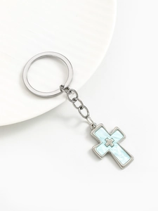 Macro detail of a silver alloy double cross keychain with blue marble resin inlay