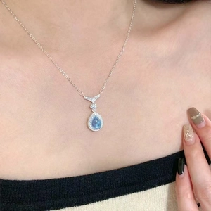 Macro shot of mermaid teardrop necklace with blue gemstone and shimmering diamonds