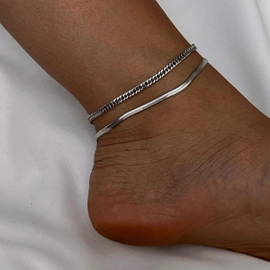 Detail of silver layered anklet featuring curb chain and flat snake chain on ankle