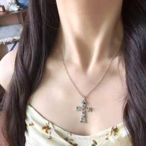 Primer plano del collar con colgante de cruz de flores coloridas en una modelo