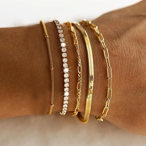 Detail of five-piece gold layered chain bracelet set with crystals on a woman's wrist