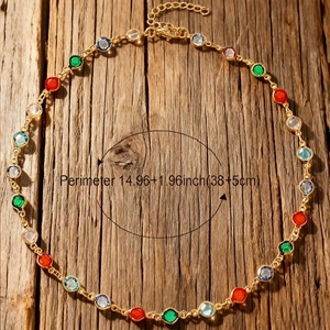 Collar de cadena dorada con piedras redondas de colores sobre fondo de madera