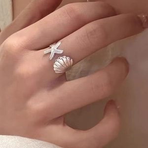 Dettaglio dell'anello regolabile in argento con stella marina, conchiglia e cristalli