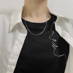 Collier minimaliste en maille serpent argentée porté par un mannequin sur un t-shirt